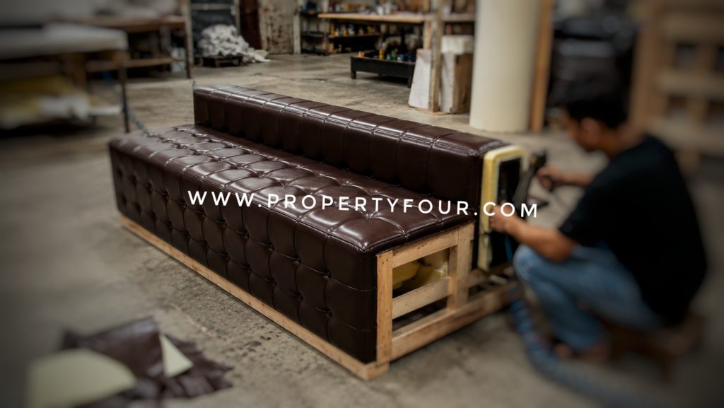 Proses pelapisan sofa custom menggunakan bahan kulit sintetis pilihan di workshop Propertyfour.